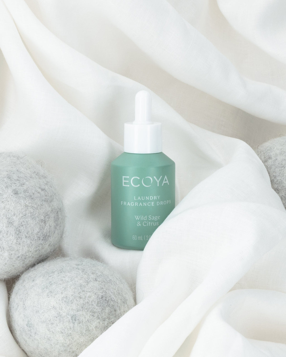 Ecoya Wild Sage and Citrus fragrance drops being applied to a wool dryer ball