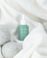 Ecoya Wild Sage and Citrus fragrance drops being applied to a wool dryer ball