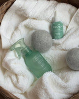 Ecoya Wild Sage and Citrus linen spray beside folded bed linen