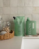 Ecoya Wild Sage and Citrus laundry liquid on a laundry shelf beside towels