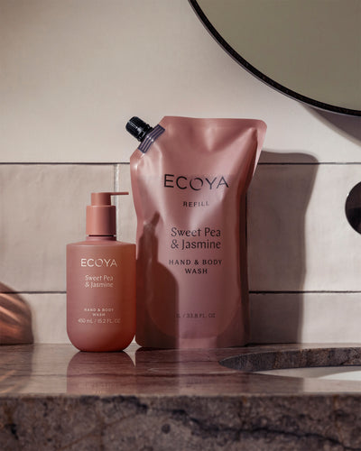 Ecoya Sweet Pea & Jasmine refill pouch and bottle on a marble bench beside a mirror