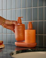 Ecoya Mandarin Gin hand and body wash and lotion on a bathroom shelf