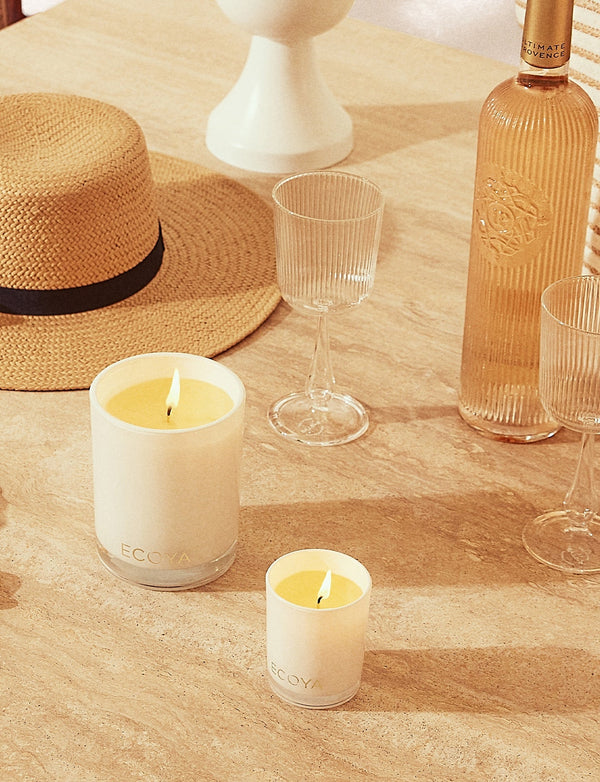 A Scandinavian home design with a Sensory Escapes: Yuzu & Sandalwood Madison Candle by Ecoya and a straw hat.