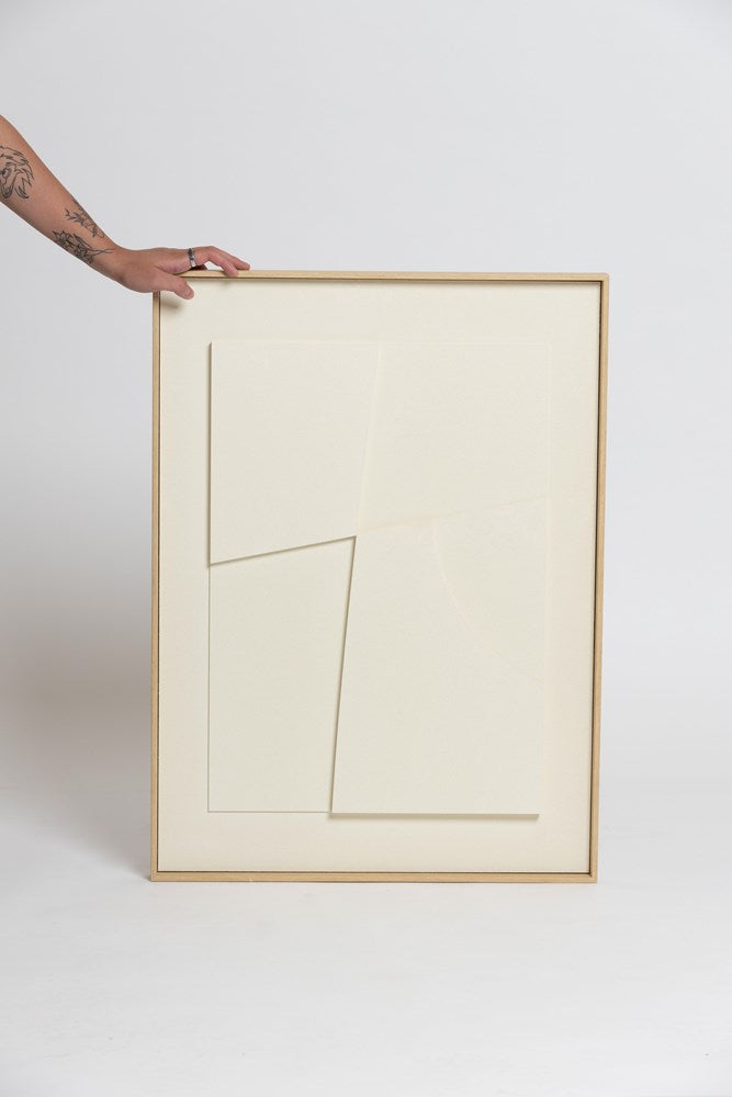 A person holding up a framed piece of white Laan Print paper from Ned Collections.