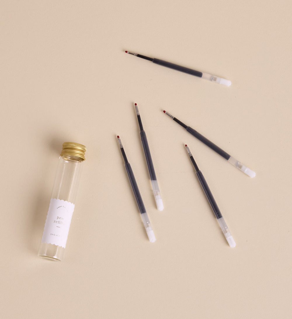 Pen refill cartridge being inserted into Emma Kate Co rollerball pen