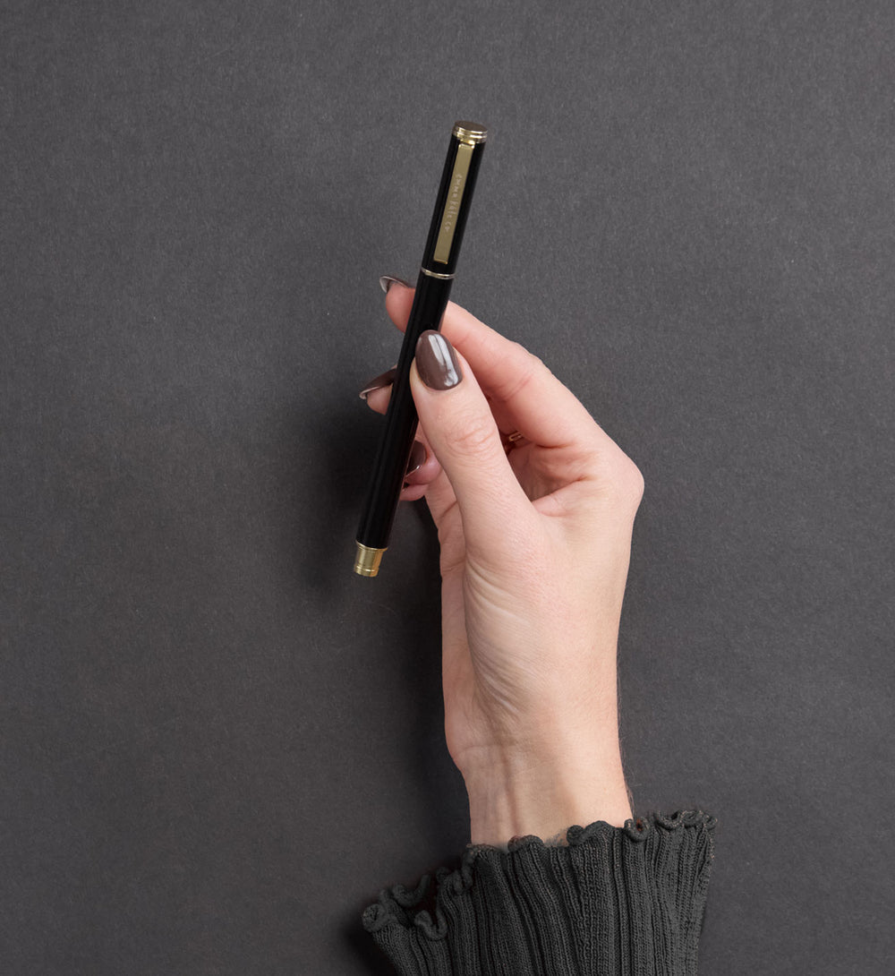 Metal Rollerball Pen in Nero styled on desk with notebook by Emma Kate Co