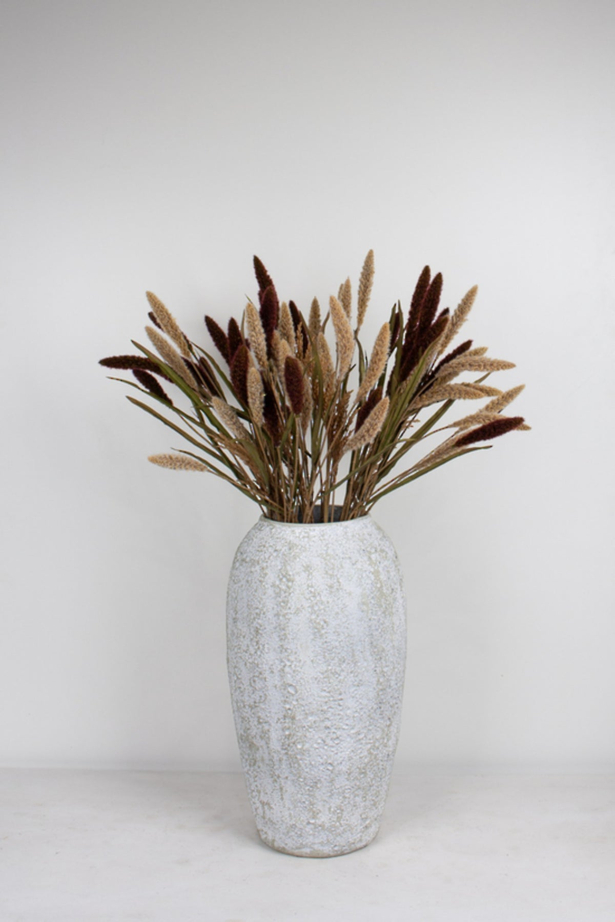 Alfresco Outdoor Pot, large, holding tall burgundy and brown dried-look leaf stems