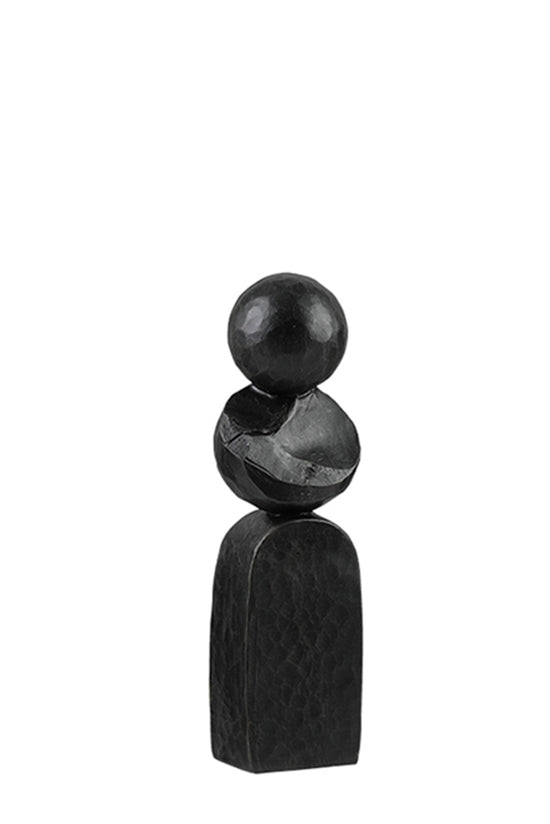 Small black Pillar sculpture of stacked rounded stones on a plain background