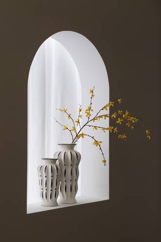 Two Zara vases in an arched alcove with a branch of yellow blossom