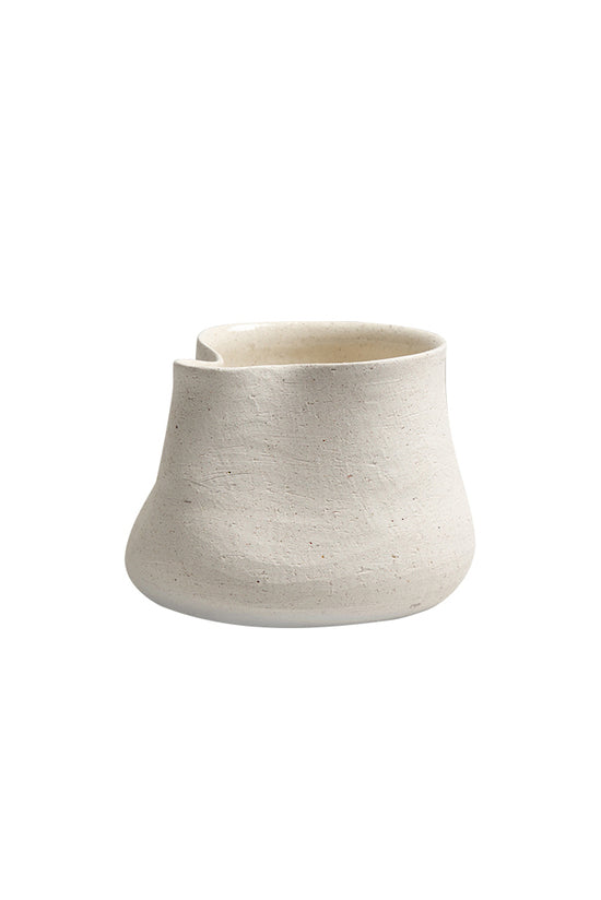 Sandface pinched form pot in textured sand ceramic, plain background