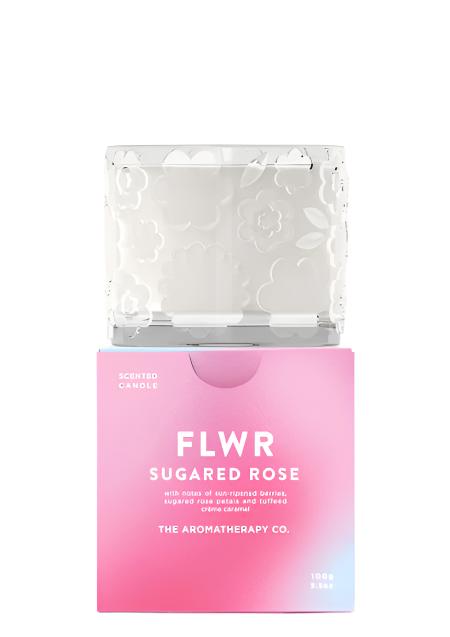 The FLWR Sugared Rose candle standing on its pink gradient gift box, shown on white