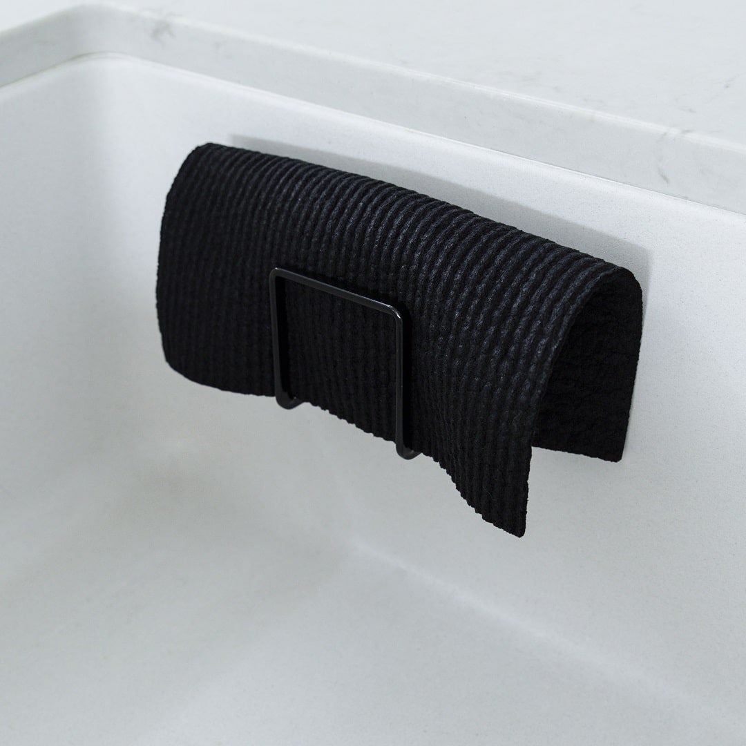 Black cloth folded over the edge of a white sink