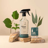 Good Change bathroom spray bottle with eucalyptus cleaner resting on rocks.