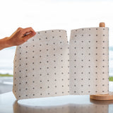 A person holding a Good Change reusable bamboo towel with polka dots on it.