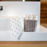 An eco-friendly bathroom sink with a basket of Good Change reusable bamboo towels.