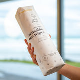 A person holding a package of Good Change reusable bamboo towels in front of a window.