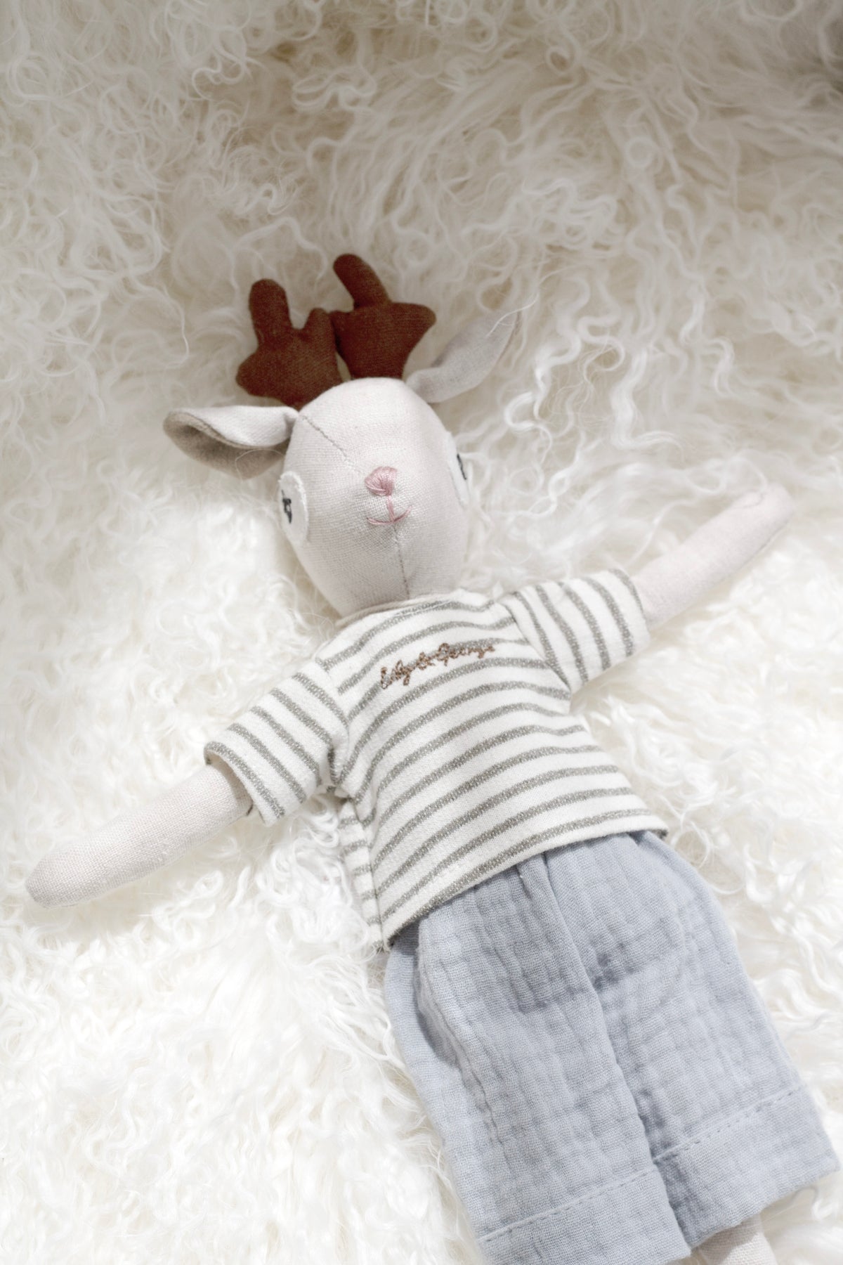 Gabriel the Deer doll on white sheepskin, close view