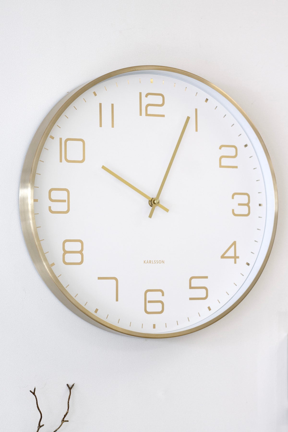Karlsson Elegance Glow in white on a wall above wall hooks