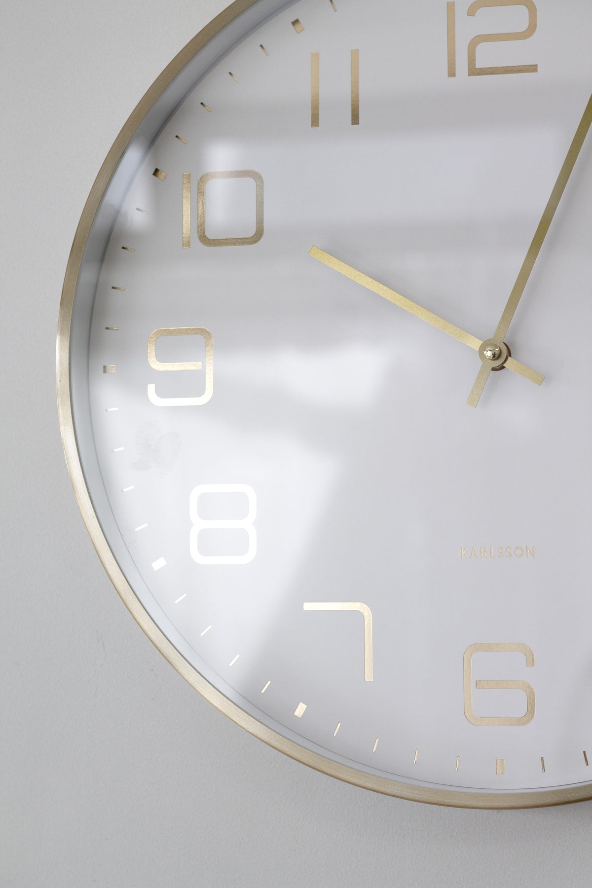 Angled close-up of the white Elegance Glow showing the gold rim and hands