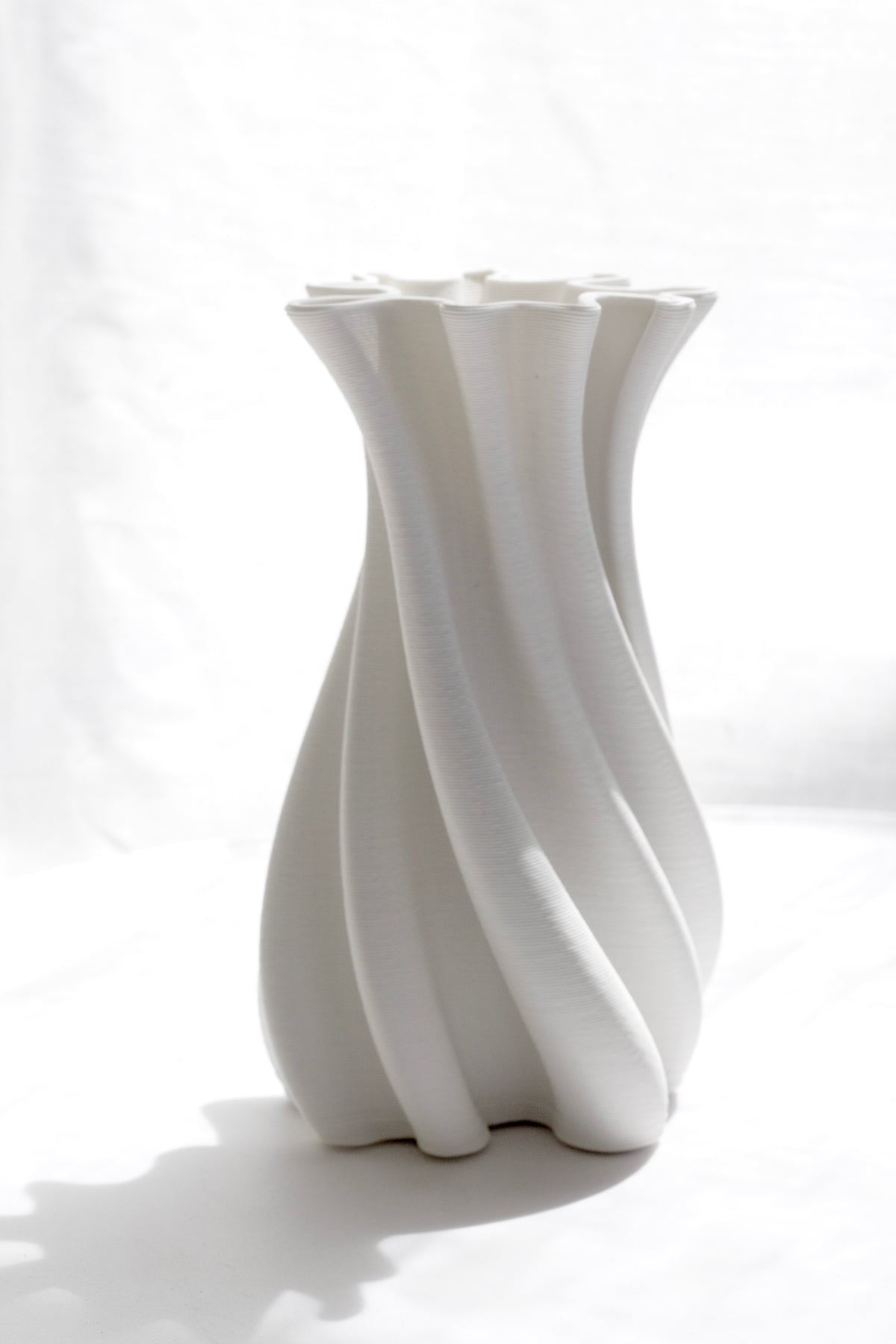 White Camila vase in soft window light showing its twisting flutes