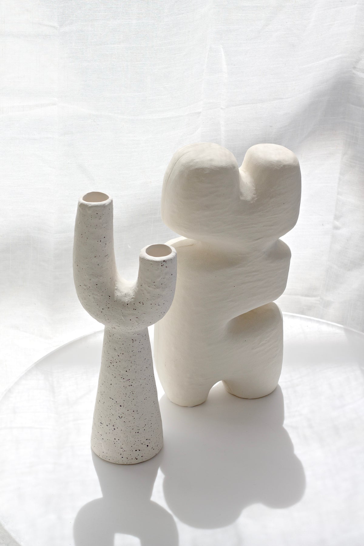 Franki vase beside a stacked white sculpture in soft light