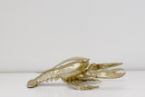 A Flux Home gold lobster ornament displaying height on a white surface.