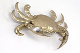 A Flux Home brass Crab Ornament - Gold on a white wall with depth.