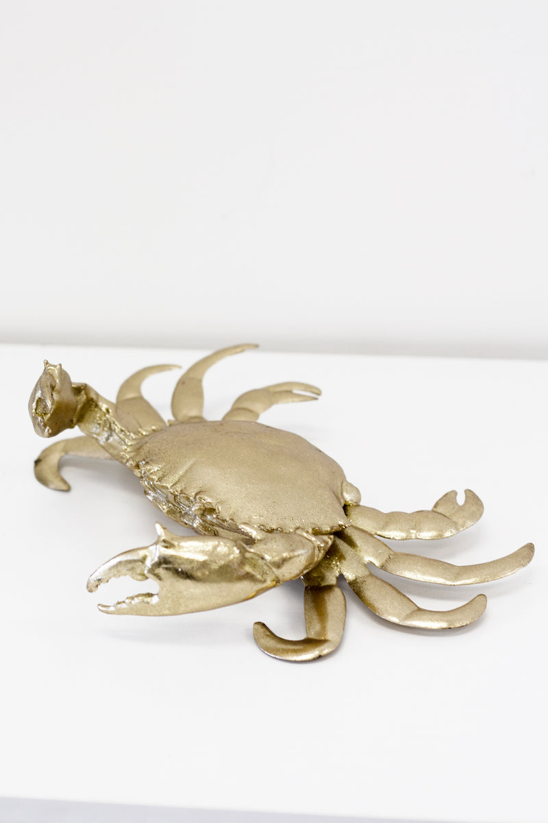 A Flux Home Brass Crab Ornament - Gold with a white surface.