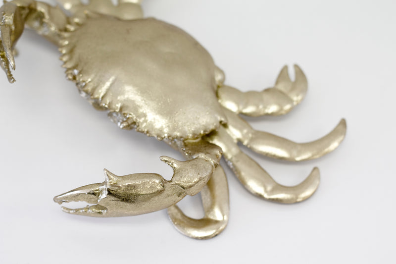 A Crab Ornament - Gold with claws on a white surface made by Flux Home.