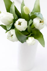 White Tulip Bouquet from Artificial Flora in a white vase on a table.