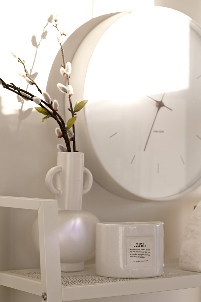 A modern LOUIS VASE BLACK / WHITE shelf with a clock on it from Ned Collections.