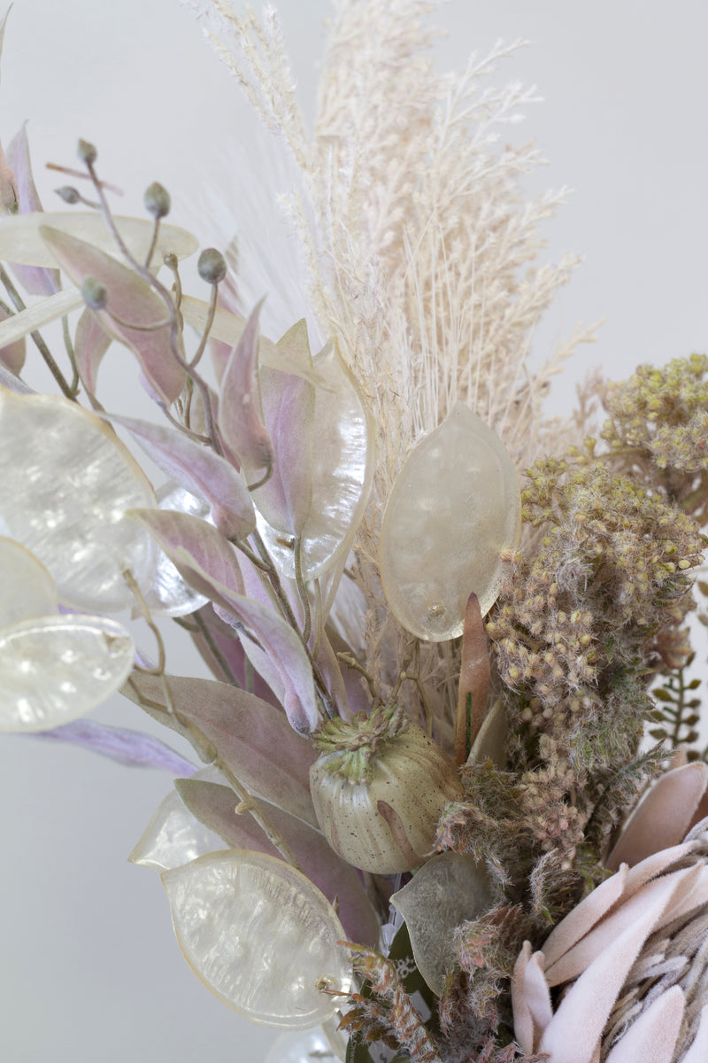 A stunning arrangement of Artificial Flora's Dried Protea - Large with hints of greenery in a vase.