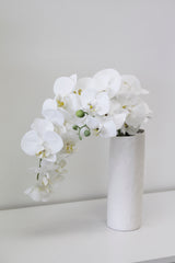 A white vase with Real Touch Moth Orchid White by Artificial Flora in it.