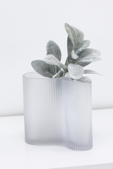 A white vase with a Lambs Ear with 16 Leaves from Artificial Flora in it, perfect for adding a touch of greenery to any space.