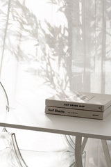 A white Eat, Drink, Nap table with Books on it, perfect for interior design or hosting a party with catering.