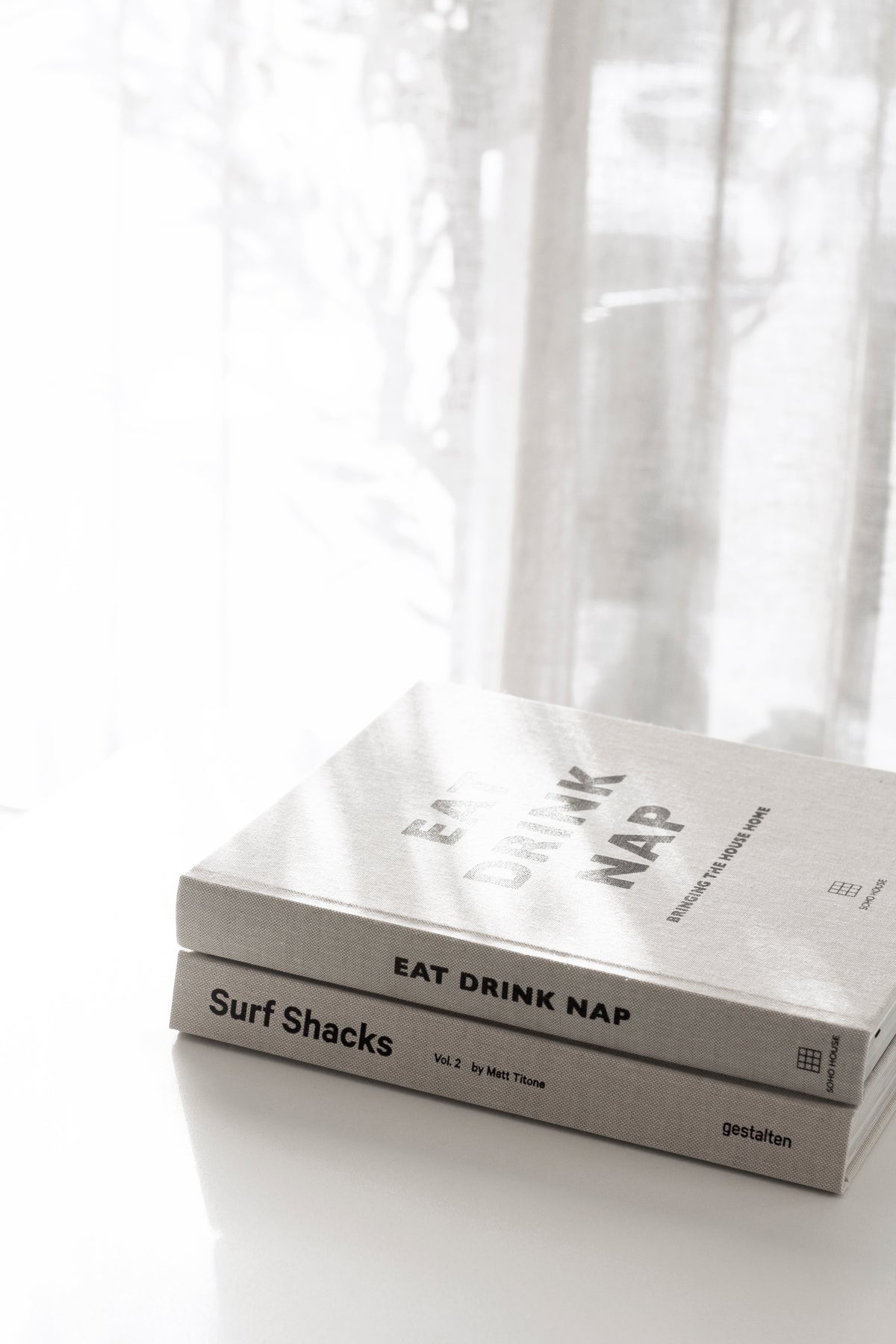 Surf Shacks Volume 2 and Eat Drink Nap stacked on a white table, close-up