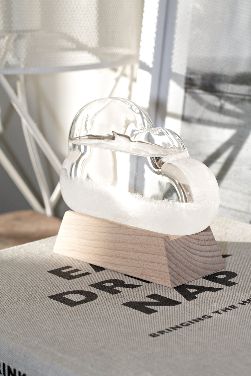An Albi Cloud Weather Station with a mesmerizing play of colors and light on top of a book.