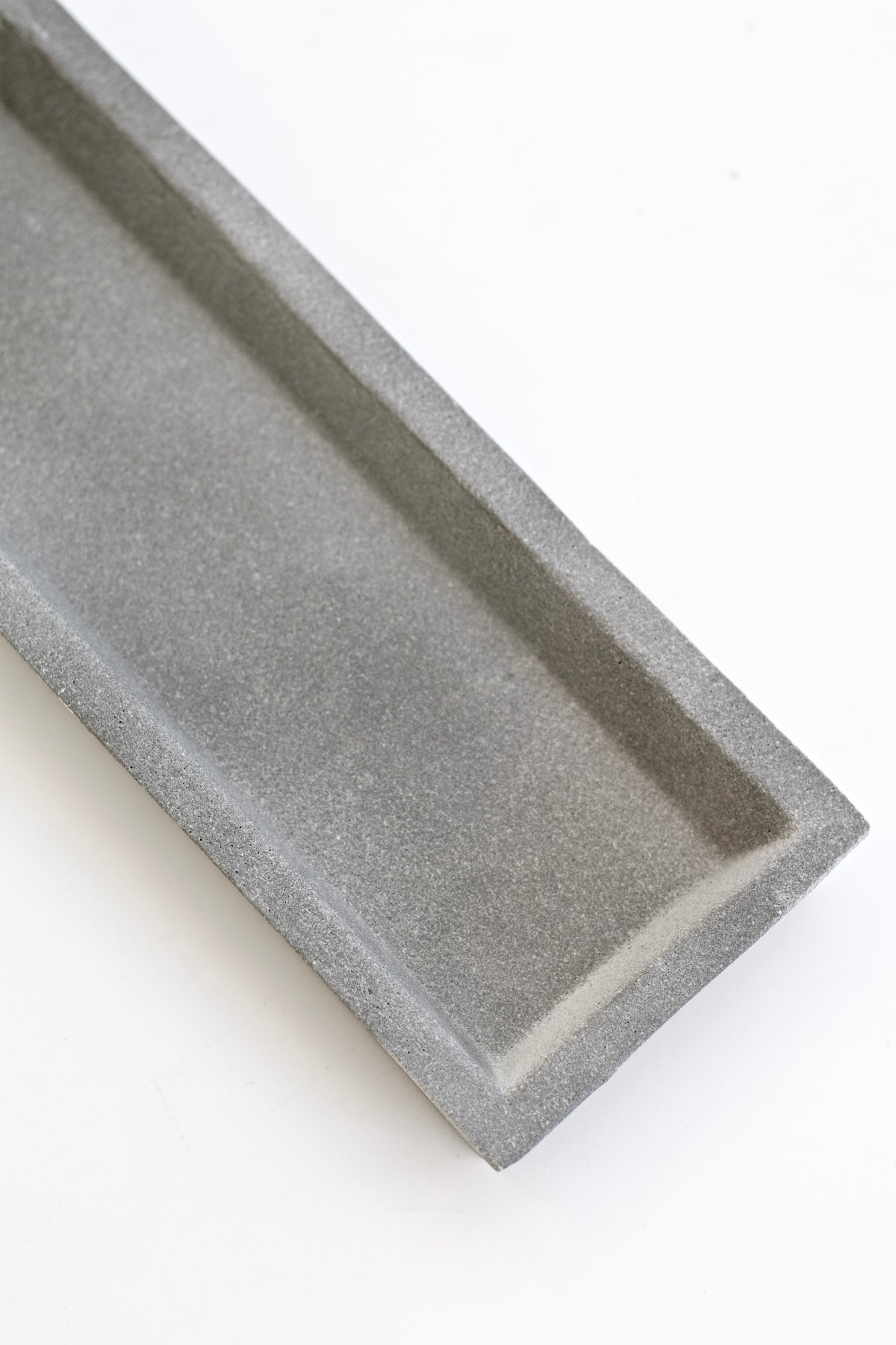Close-up of the natural concrete tray showing its speckled surface and raised edge