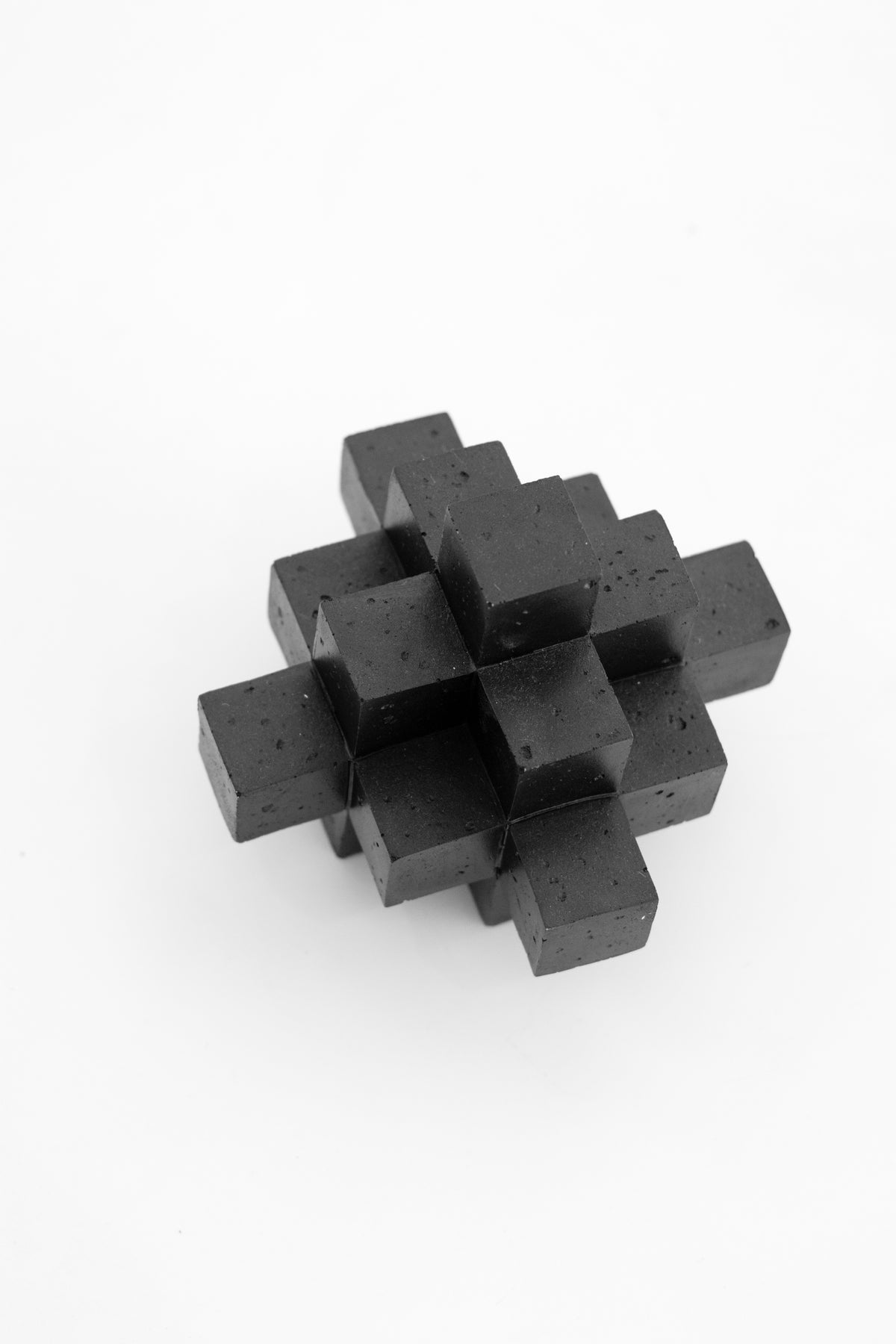 Black Cubism sculpture on a pale background, showing the stacked cube form