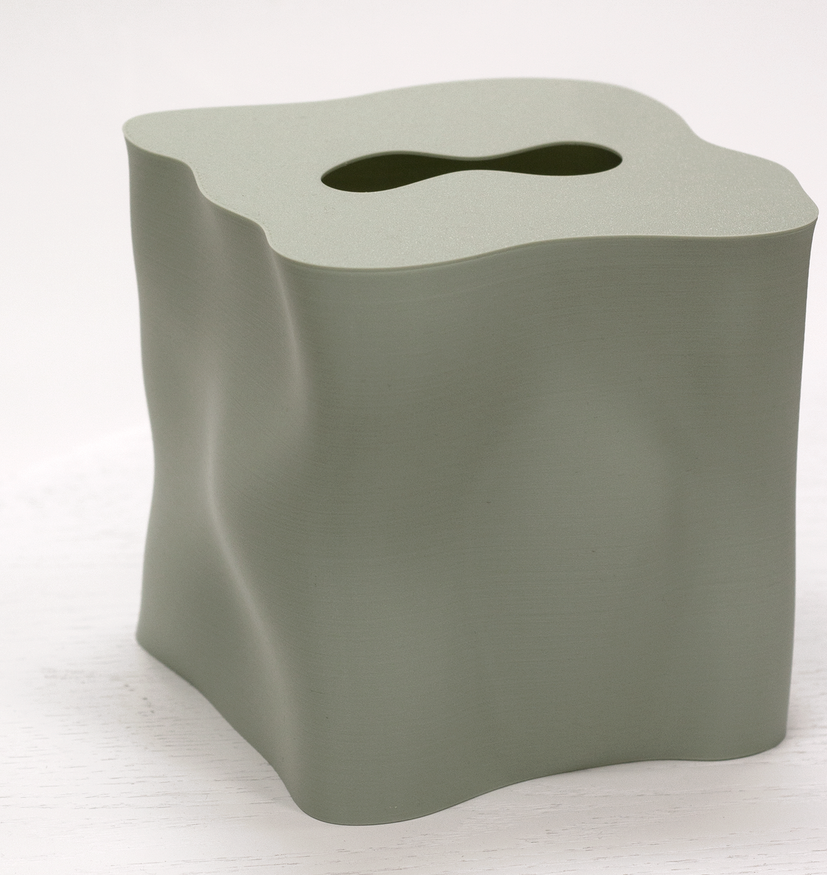 Ebb tissue box cover in sage green, showing the sculptural rippled form and shaped opening