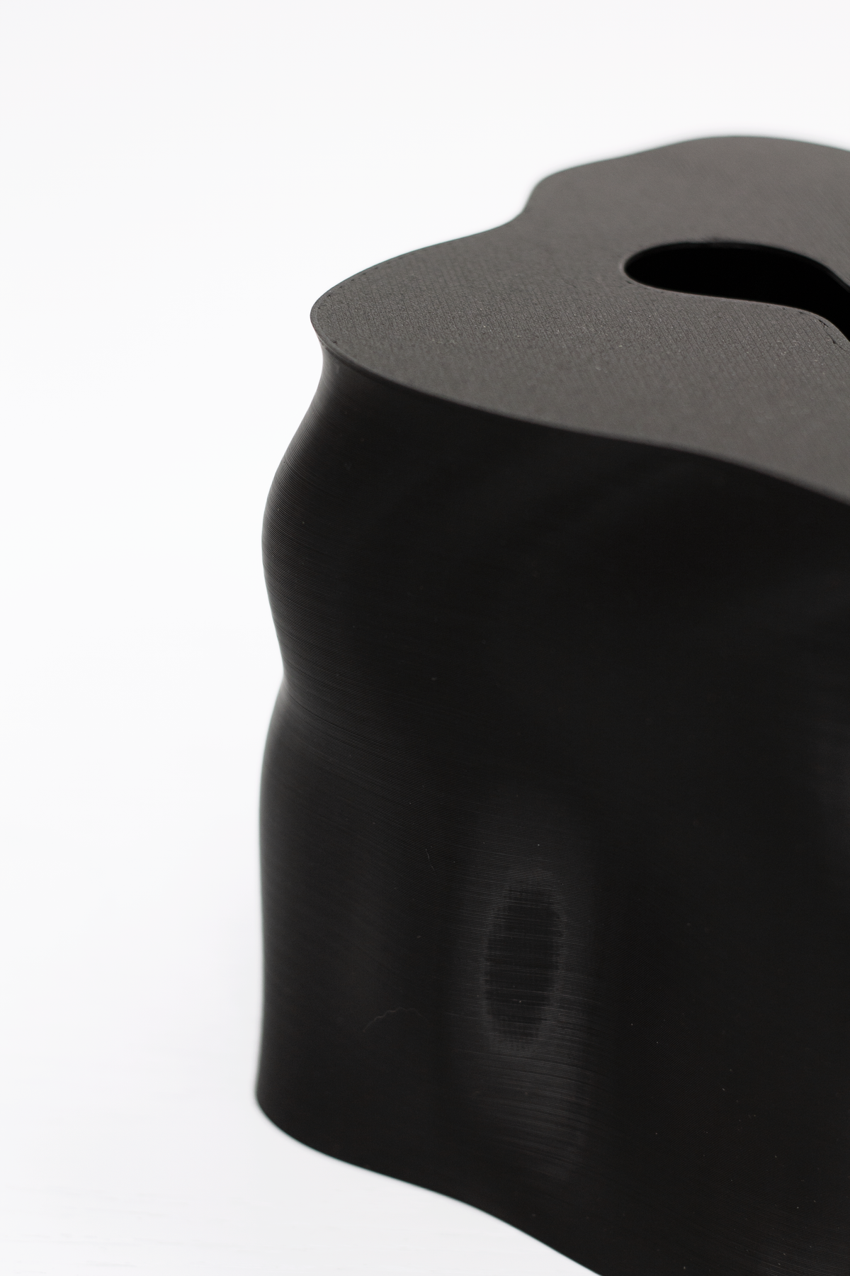 Angled close up of the black Ebb tissue box cover showing its undulating sides