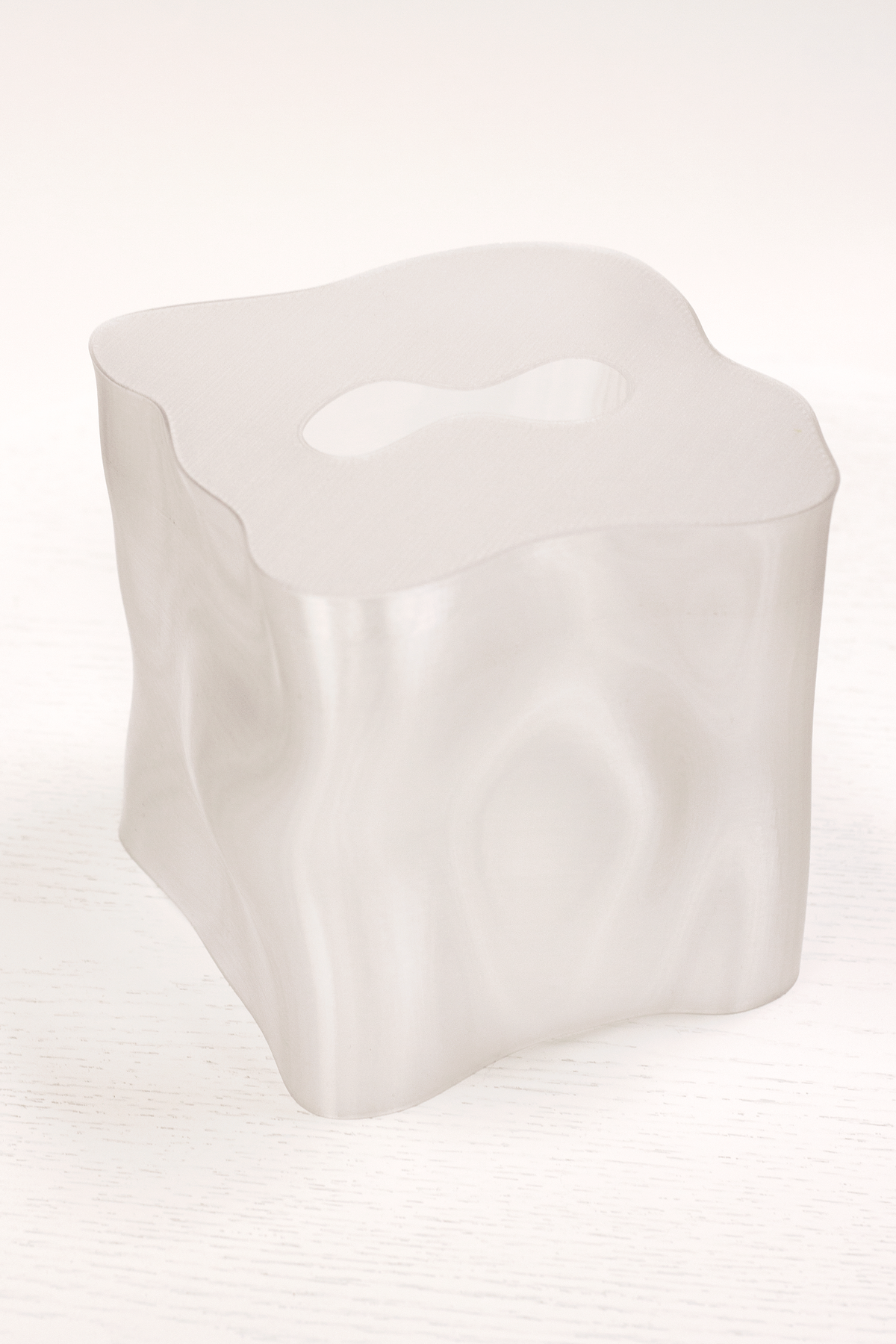 Ebb tissue box cover in frosted translucent white, showing the rippled sculptural sides and shaped opening