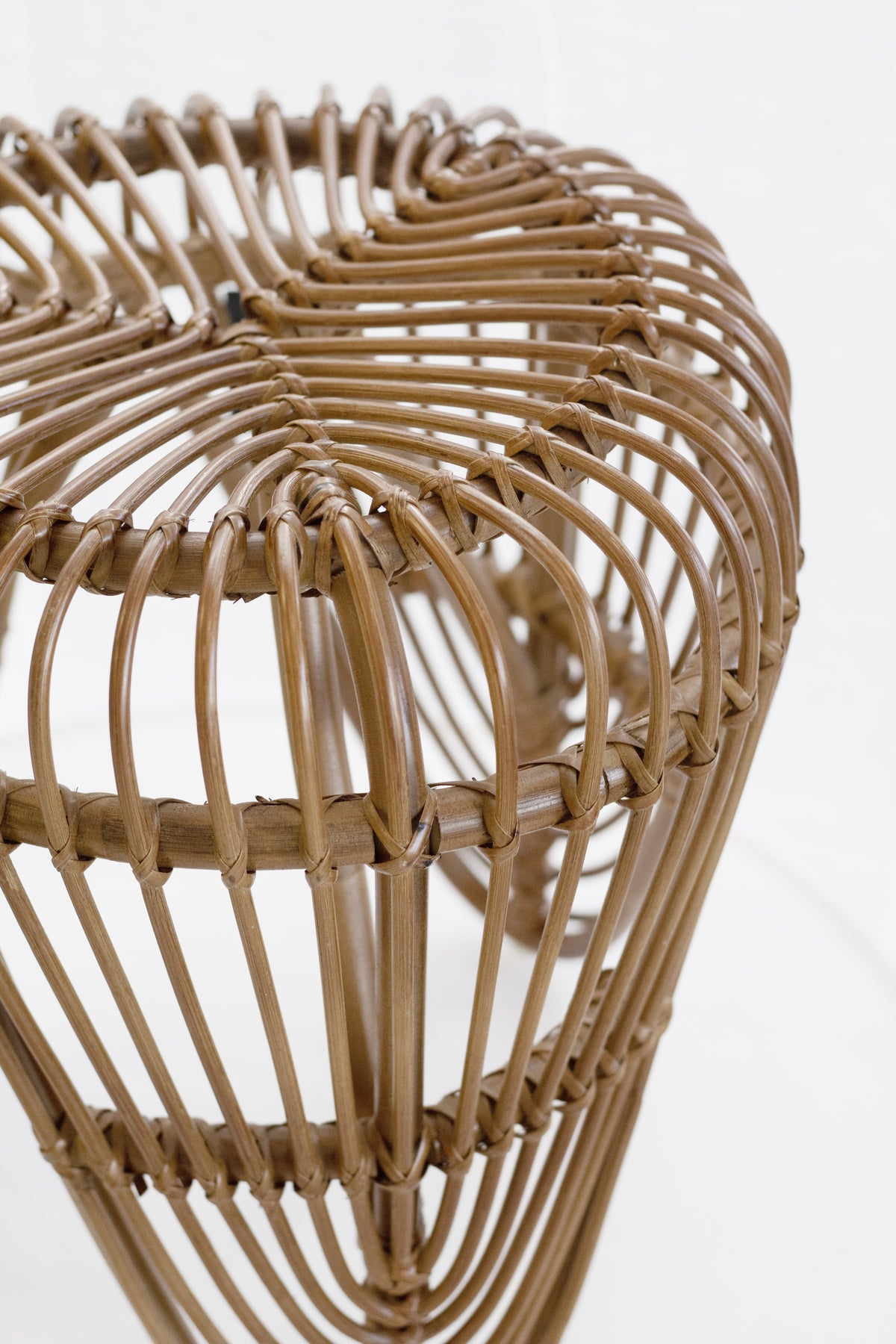 Close view of the woven rattan on the tulip stool, showing the bentwood ribs