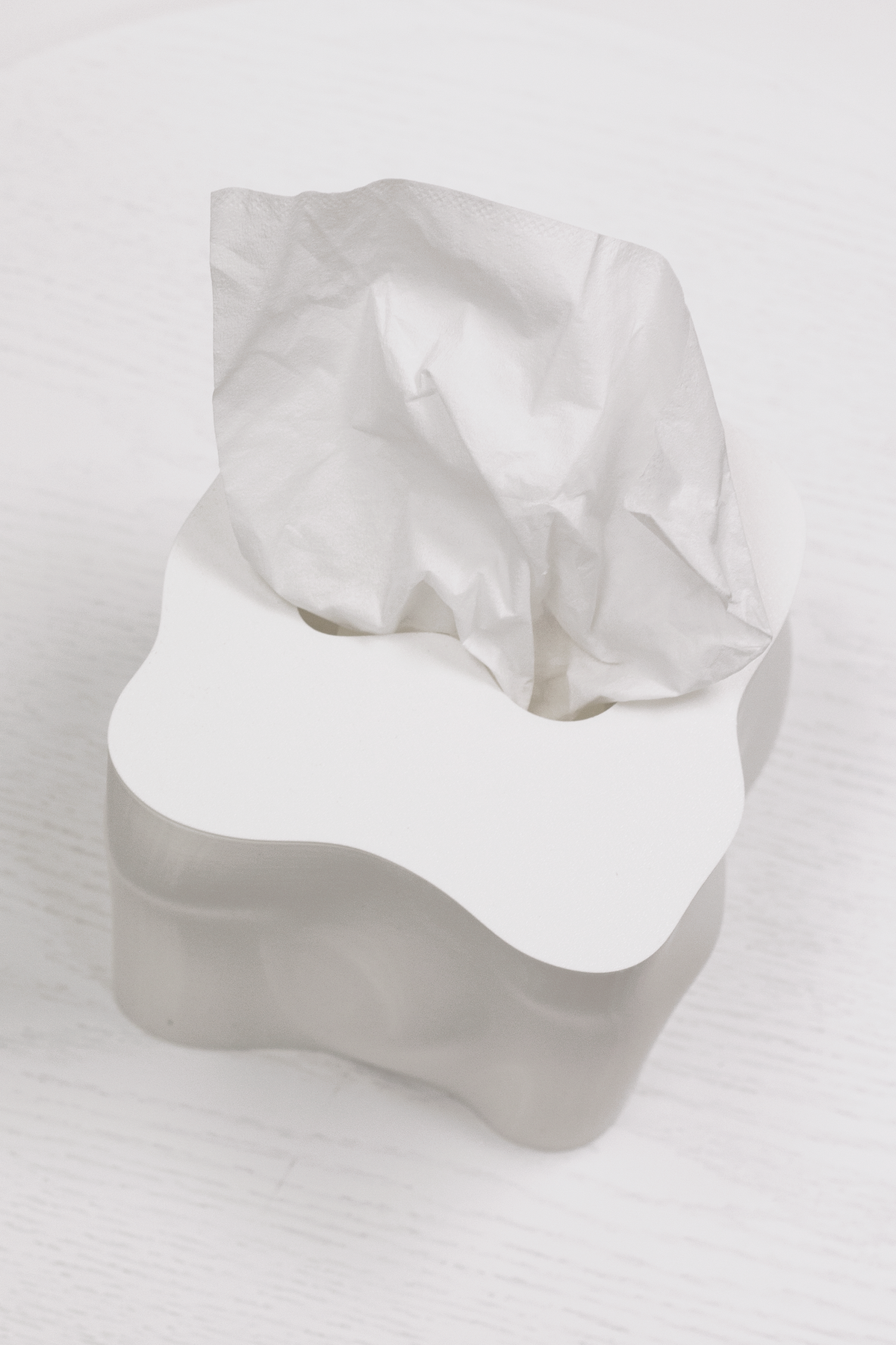 Frosted white Ebb tissue box cover with a tissue drawn up through the top