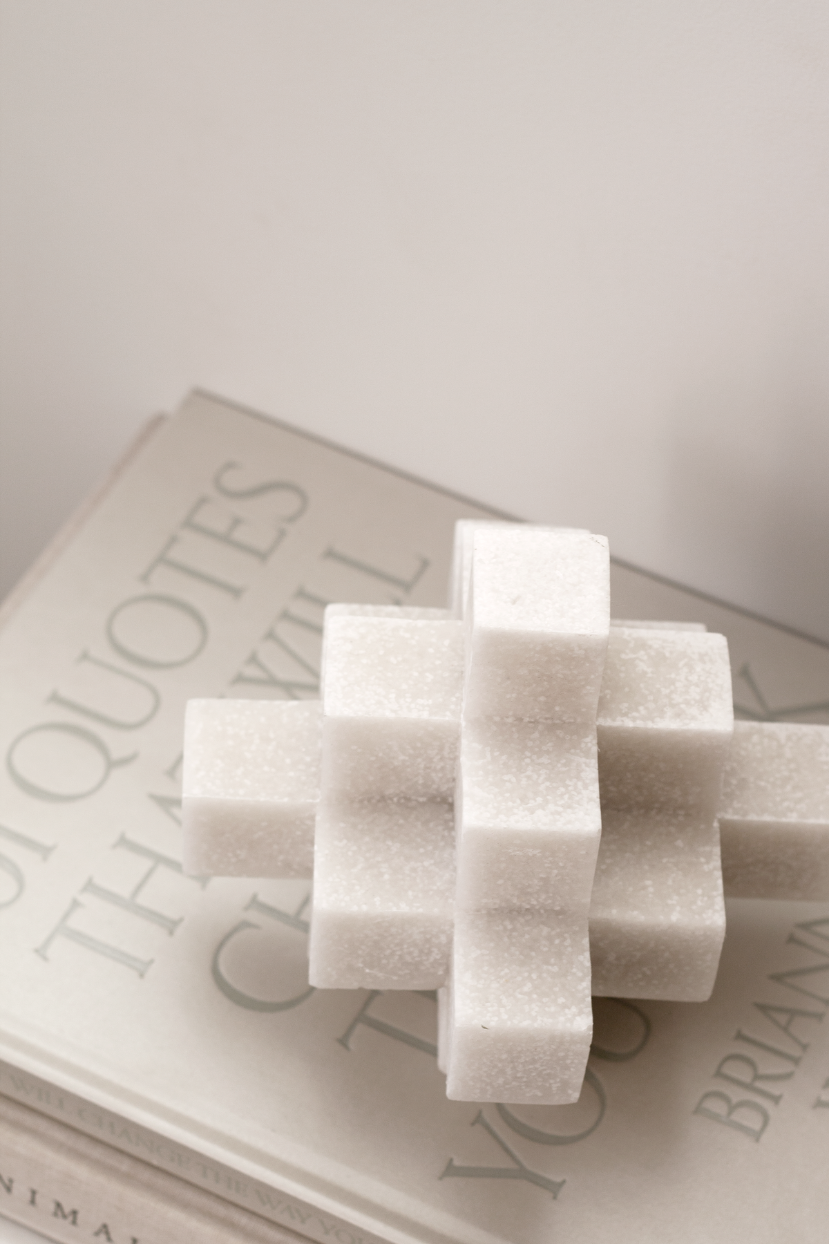 White Cubism sculpture resting on a hardback book