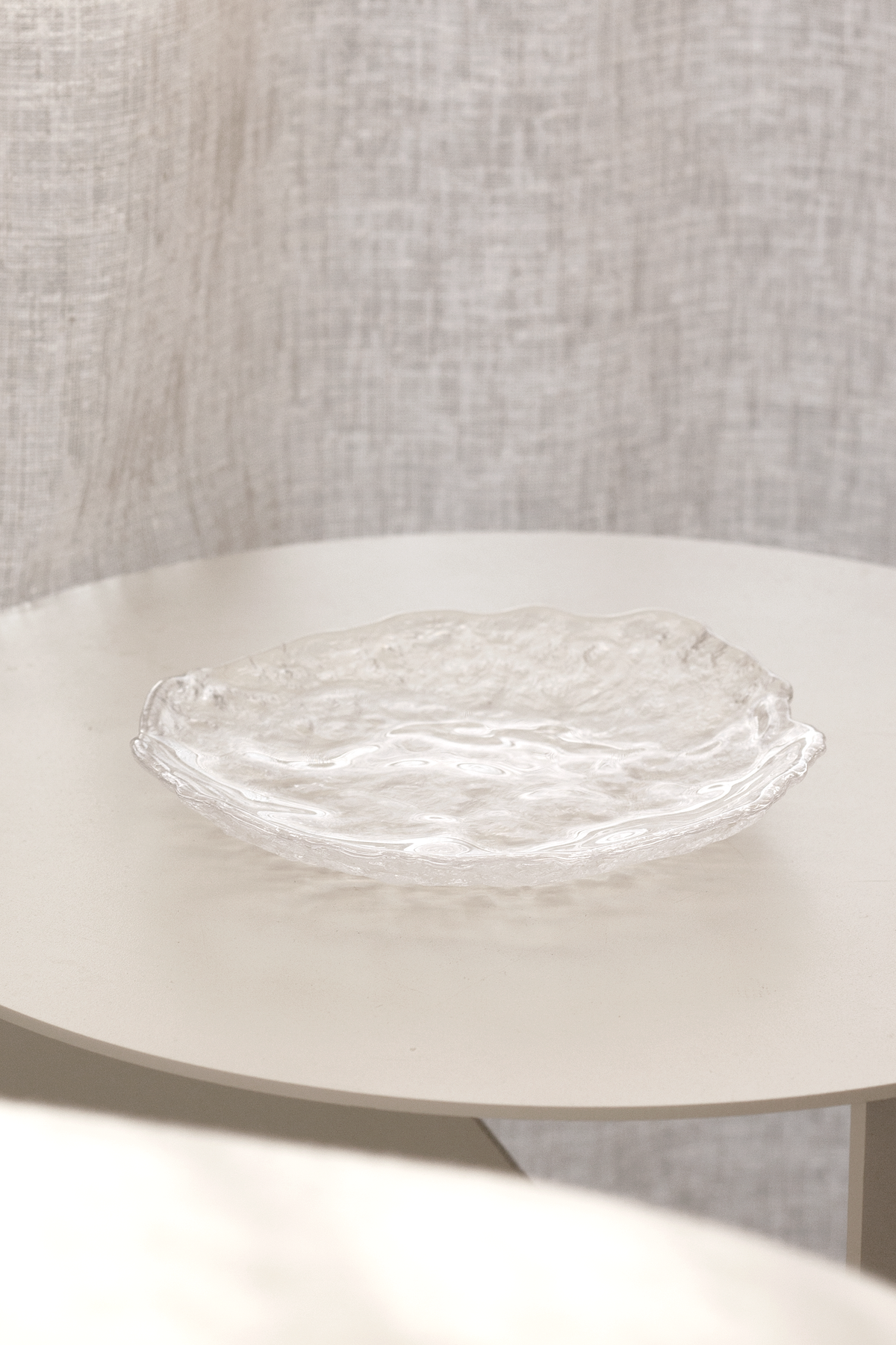 Glacier glass tray resting on a fluted pedestal against a linen backdrop