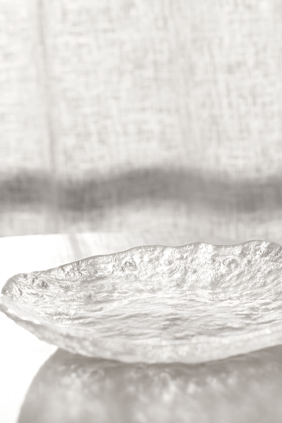 Glacier glass tray on a pedestal, side view showing its shallow depth