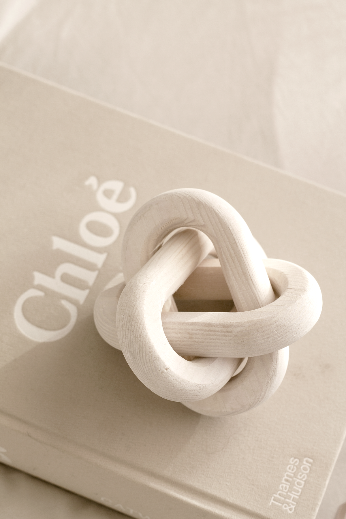 Close view of the cream knot on a book, links crossing over one another