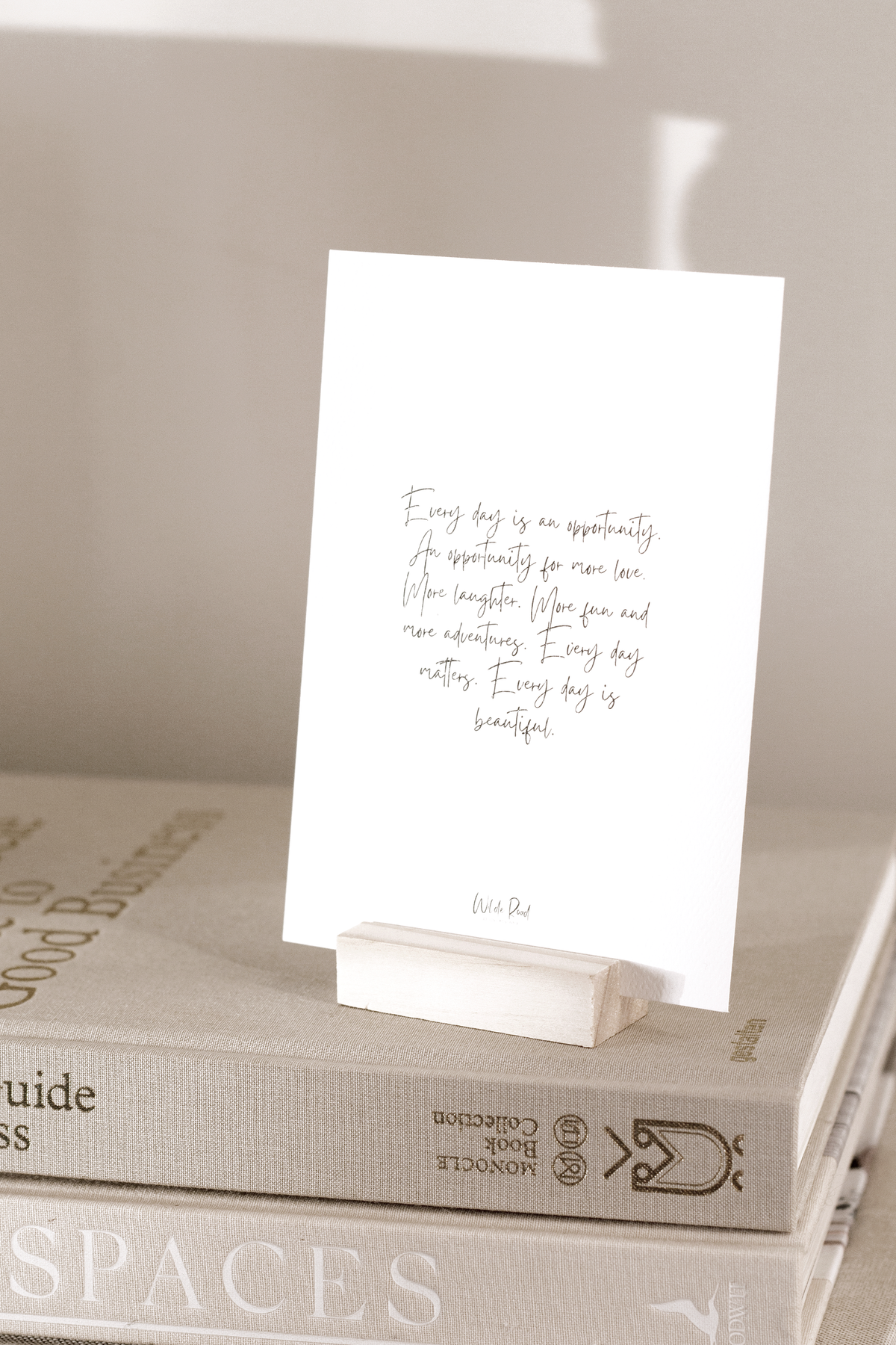 Affirmation card on a wooden stand resting on stacked books
