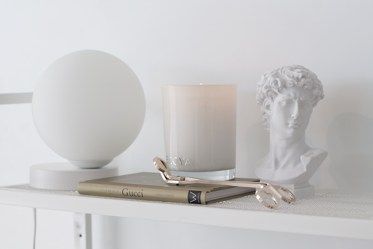 Yuri Table Lamp with a candle and a bust sculpture on a white shelf, landscape view